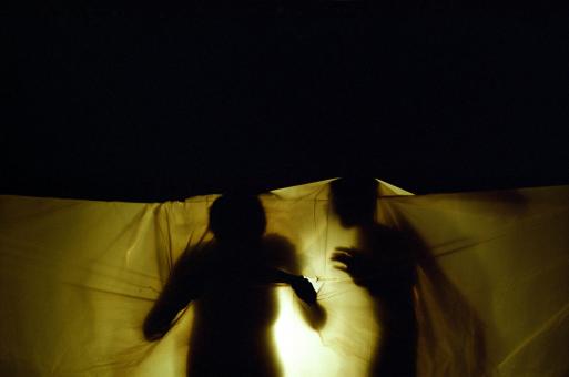 Saynète de la représentation de fin d'année du cours de théâtre du Centre de Formation et de Rééducation Professionnelle (CFRP) de l'AVH : deux silhouettes sous une bâche de plastique éclairée par-derrière. Paris, juin 2005.