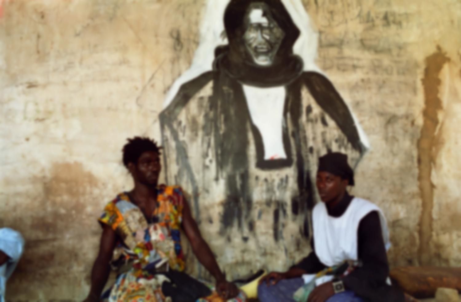 Ousmane pose avec un autre Baye Fall devant un mur décoré d'un grand portrait d'Ibrahima Fall. Touba, Sénégal, février 2008.