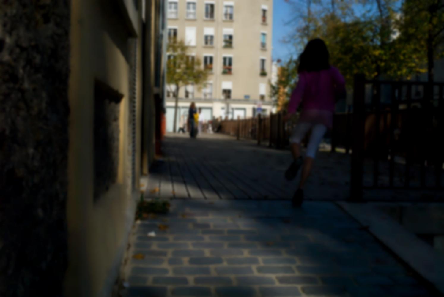 Une petite fille monte en courant la rampe pavée et se précipite dans l'ombre du parvis de caillebotis devant la résidence universitaire du quai de la Loire. Au fond, les immeubles de la rue de Crimée prennent le soleil. Paris, octobre 2009.