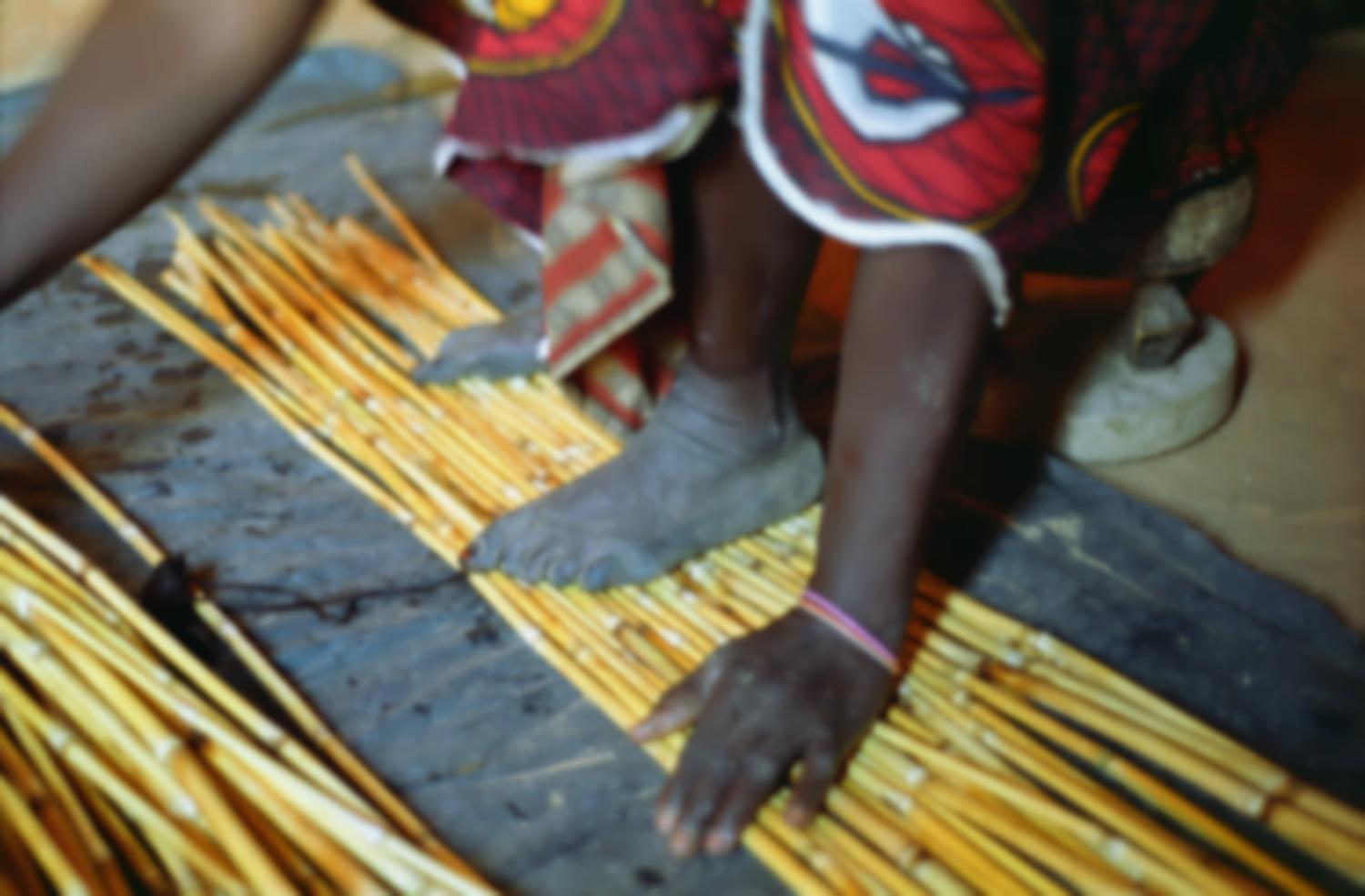 Les pieds et une main de Rakia alors qu'elle assemble les premières cannes d'une nouvelle natte. Bosseye Dogabe, Burkina Faso, mai 2008.