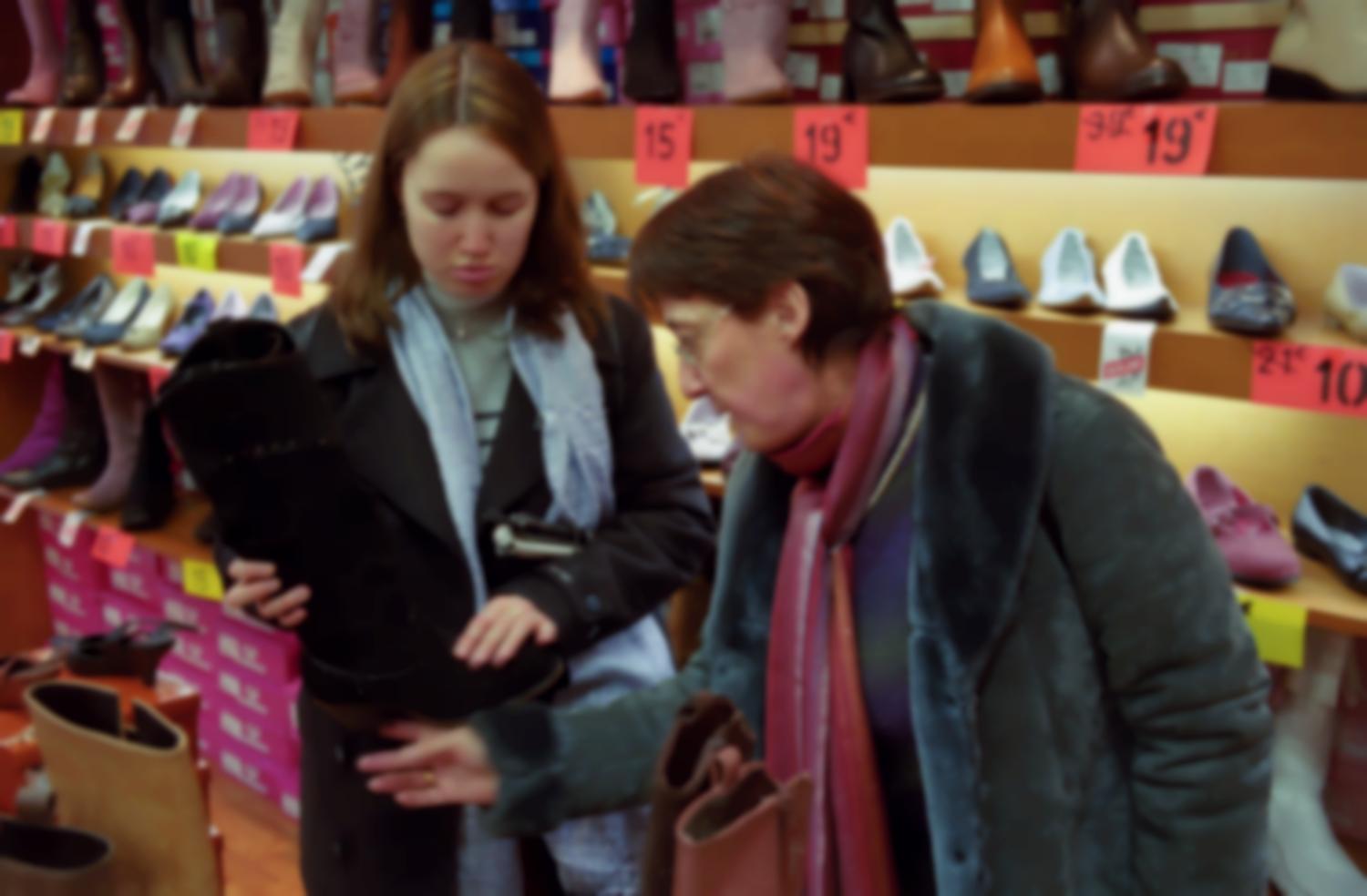 Céline et sa mère regardent une botte dans une boutique de chaussures. Paris, janvier 2006.