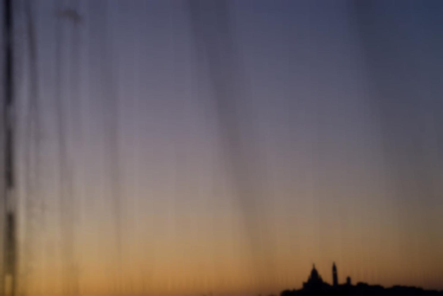 Derrière le filet de l'échafaudage, la silhouette du Sacré-Cœur dans un crépuscule coloré. Paris, décembre 2009.