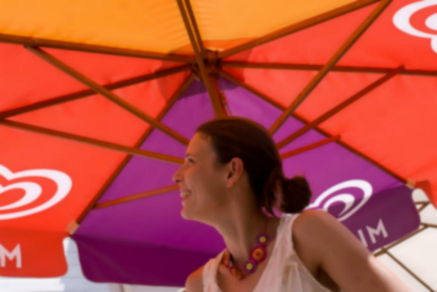 Solveig souriante sous un parasol mauve, rouge et orange. Arradon, août 2009.