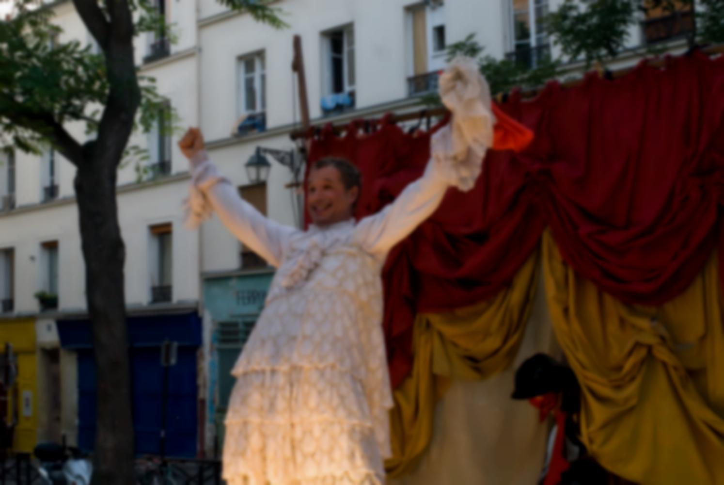 L'homme travesti vient d'ôter sa coiffure de femme et exulte, tandis qu'un autre personnage entre en scène. Paris, août 2010.