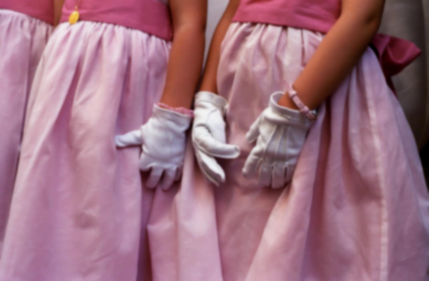 Trois petites filles d'honneur en robes roses et gants blancs. Paris, juillet 2006.