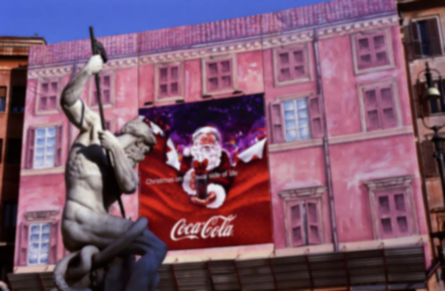 Piazza Navona, étalé sur la bâche en trompe-l'œil rose d'un échafaudage, le père Noël de Coca-Cola semble défier Neptune dans sa fontaine. Rome, décembre 2007.