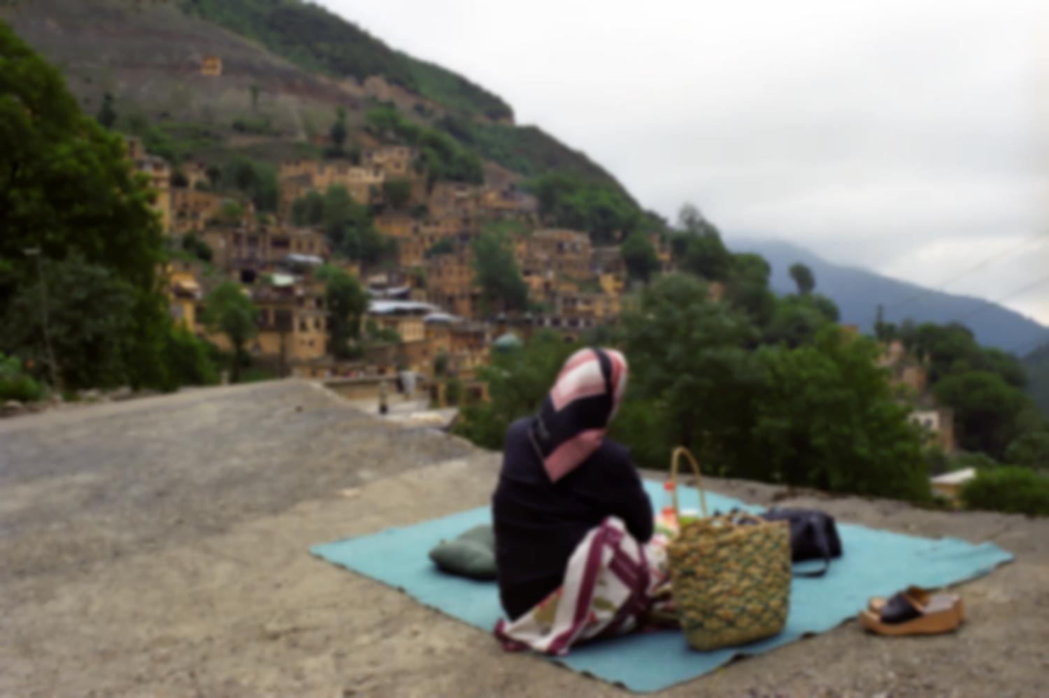 Une femme regarde le paysage depuis un toit-terrasse. Masuleh, Iran, août 2006.