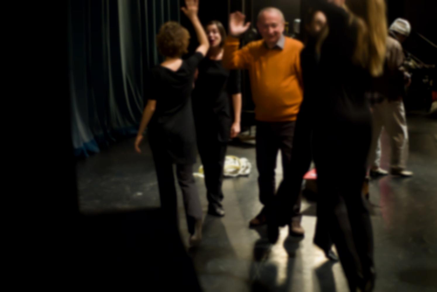 Avant la représentation, des comédiennes habillées de noir et un comédien en pull-over orange s'encouragent en se tapant les mains. Nanterre, octobre 2009.