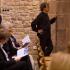 Appuyé à un pilier de l'église, le chef d'orchestre semble se concentrer, l'administratrice de l'orchestre jette un œil dans la sacristie, les premiers spectateurs lisent leurs programmes. Echternach, Luxembourg, octobre 2009.
