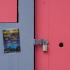 Détail d'une baraque peinte en mauve : les volets roses sont fermés, la porte rose cadenassée, et une affichette scotchée annonce le programme des bals de Paris Plage. Paris, août 2010.
