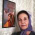 Pouri Banaee, ancienne actrice, pose devant un portrait d'elle dans sa jeunesse. Téhéran, Iran, octobre 2006.