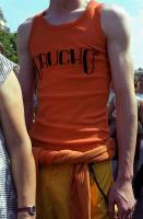 Jeune homme en débardeur orange avec l'inscription Gaucho. Paris, juin 2006.