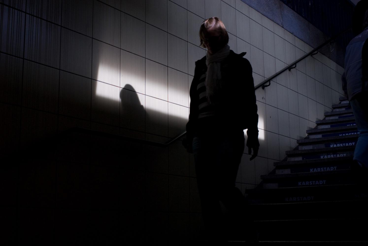 Silhouette en contrejour d'une jeune femme descendant les escaliers de la station de métro à Leopoldstrasse. Berlin, septembre 2009.
