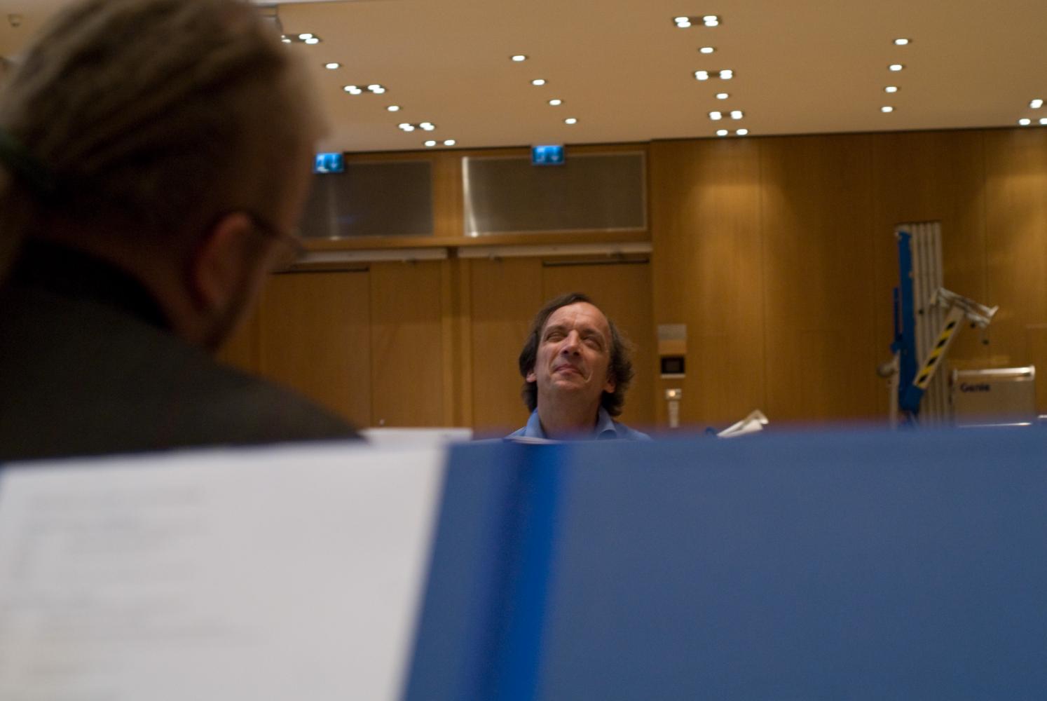 Seul le visage ravi du chef d'orchestre dépasse derrière des partitions. Echternach, Luxembourg, octobre 2009.