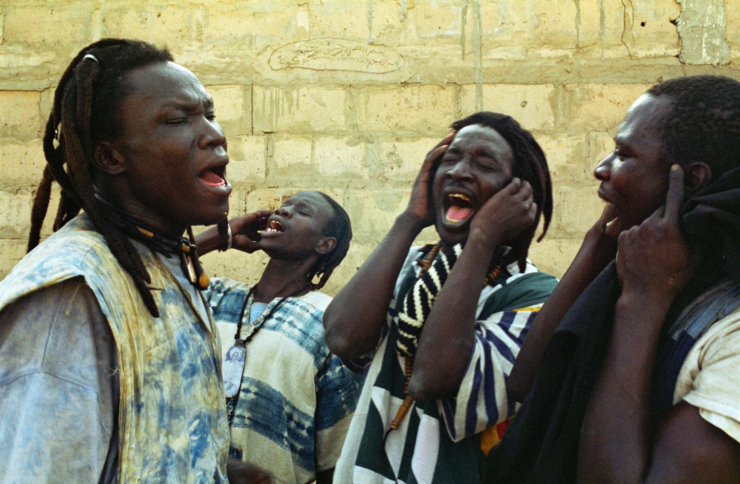 Les mains aux oreilles, quatre Baye Fall chantent. Touba, Sénégal, février 2008.