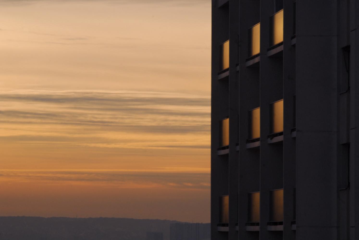 Le crépuscule se reflète dans les fenêtres de l'immeuble d'en face. Paris, décembre 2010.
