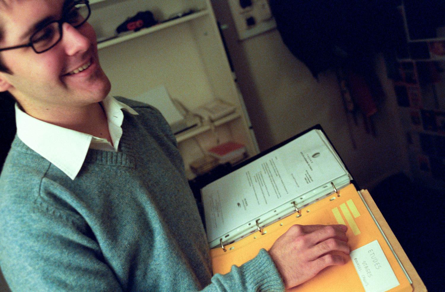 Pierre et son classeur pour les papiers administratifs, dont il déchiffre une étiquette en braille. Paris, janvier 2006.