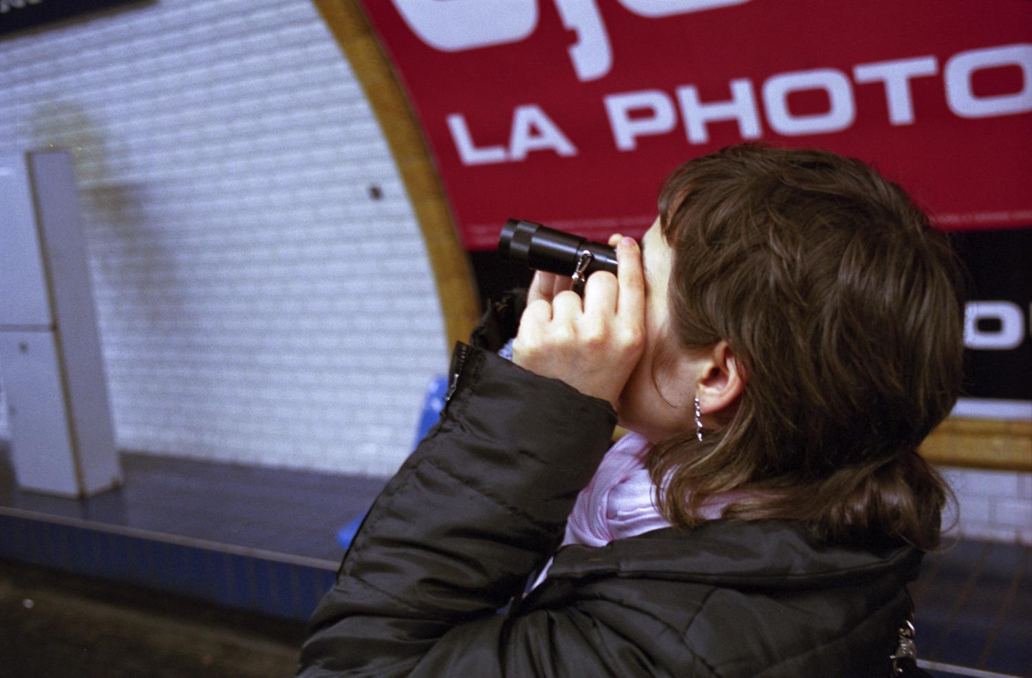 Dans le métro, Audrey utilise un monoculaire pour repérer et lire les panneaux. Paris, janvier 2006.