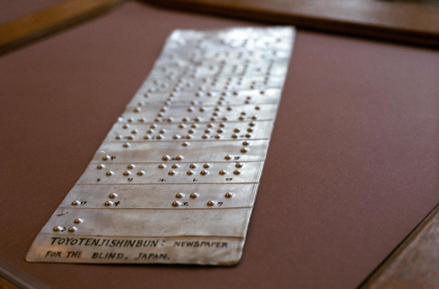 Au musée de l'Association Valentin Haüy, un plaque de métal légendée (en noir) : Toyotenjishinbun: Newspaper for the blind, Japan - décrit l'utilisation du braille en japonais. Paris, octobre 2005.