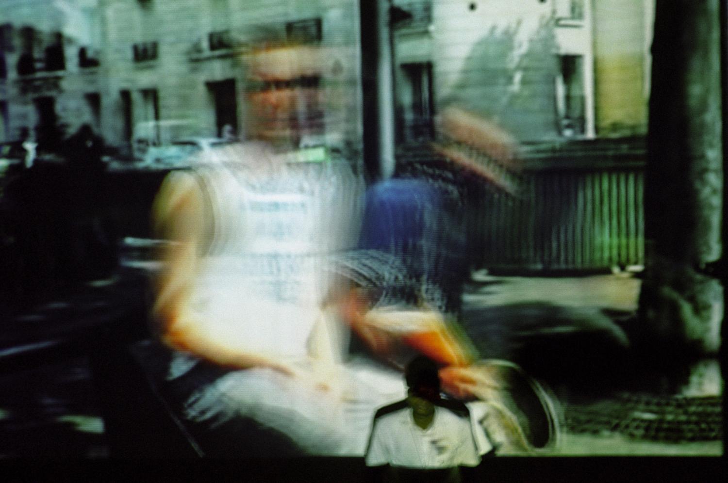 Représentation de fin d'année du cours de théâtre du Centre de Formation et de Rééducation Professionnelle (CFRP) de l'AVH : assis devant un écran où est projetée une vidéo, un stagiaire se prépare pour sa saynète. Paris, juin 2005.