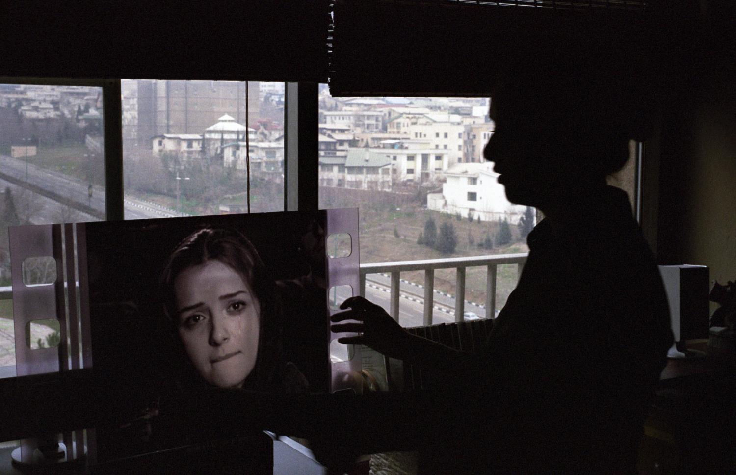 La silhouette en contrejour de Taraneh Alidousti tient un photogramme la représentant dans un court-métrage d’Abbas Kiarostami. Téhéran, Iran, février 2007.