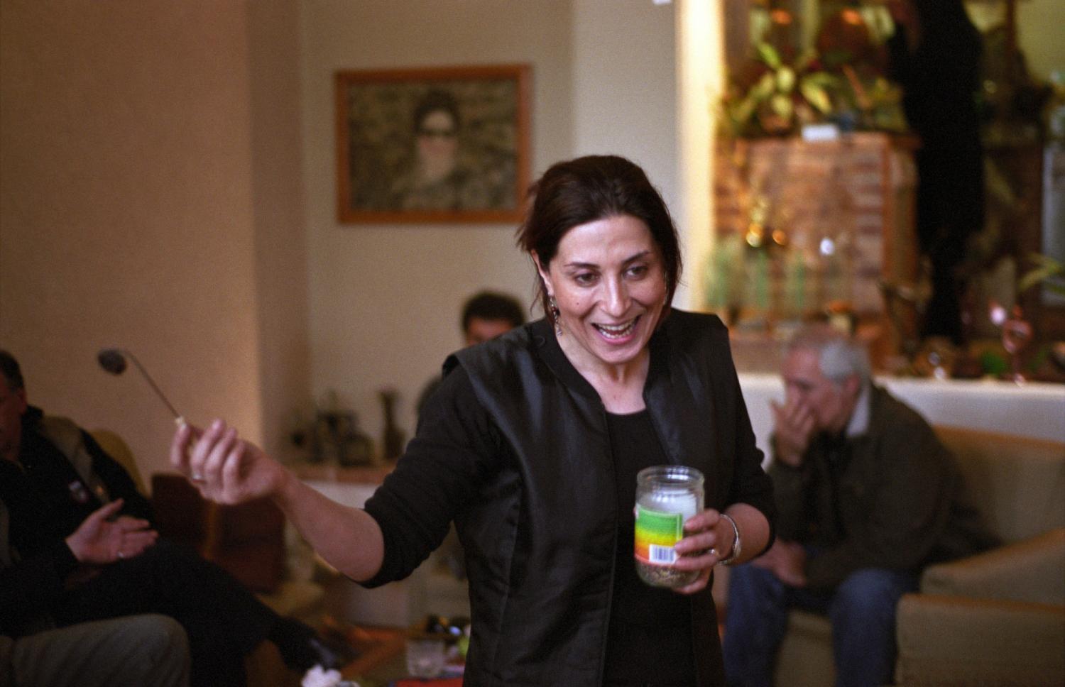 Fatemeh Motamedarya dans son salon avec des amis, un pot d'encens à la main en l'honneur de la fête d'Achourra. Téhéran, Iran, janvier 2007.