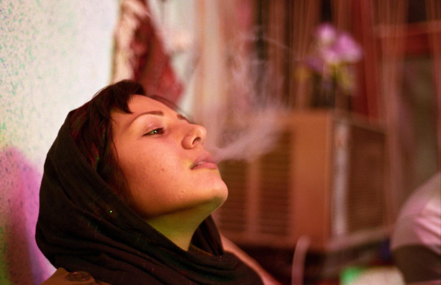 Baran Kosari fume  une pipe à eau dans une maison de thé. Téhéran, Iran, octobre 2006.