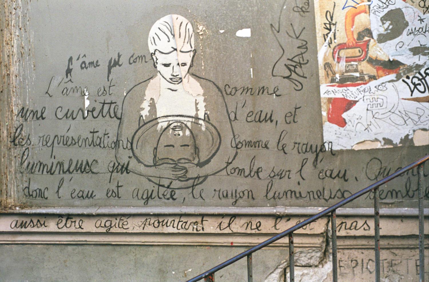 Sur un mur de Montmartre, près d'une affiche déchirée et accompagné d'une citation d'Epictète, dessin d'une personne qui regarde son reflet dans une bassine d'eau qu'elle encercle de ses bras. Paris, octobre 2008.