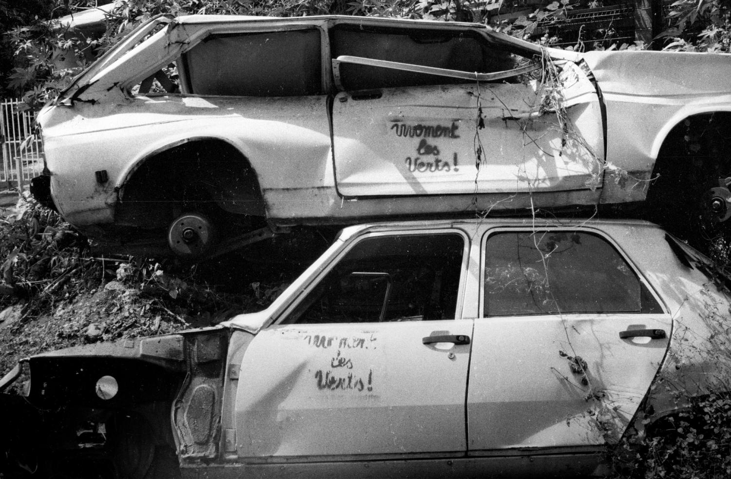 Graffitis écolos sur deux épaves de voitures blanches empilées dans la nature. Ile de la Réunion, septembre 1999.