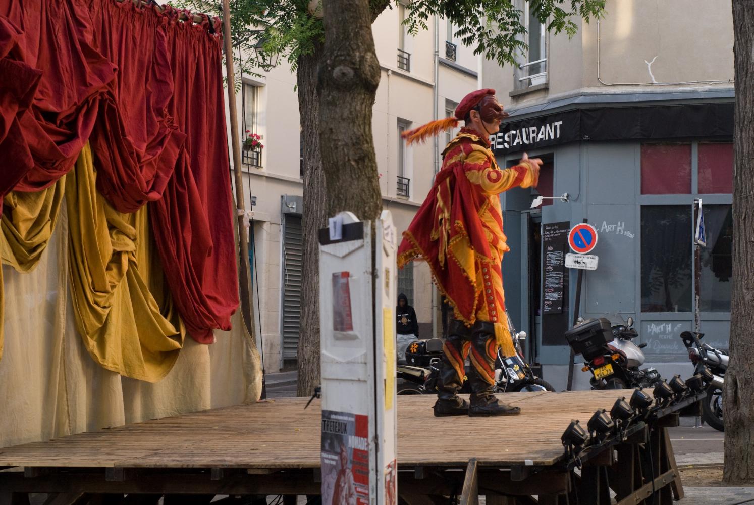 Seul sur scène, masqué, plume au chapeau et cape au dos, un capitaine. Paris, août 2010.