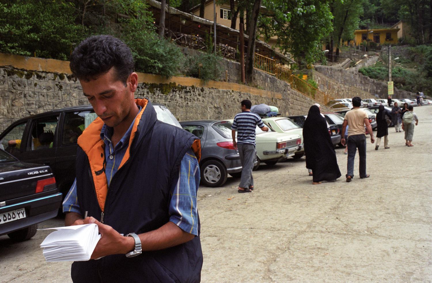 Au bas du village, le parking des voitures individuelles et l'homme qui délivre les tickets. Masuleh, Iran, août 2006.