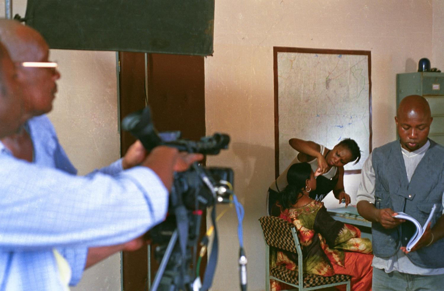 Pendant que ses collègues se préparent pour une scène, Jeanne d'Arc effectue quelques retouches de maquillage sur le visage de Laure. Ouagadougou, Burkina Faso, juin 2008.