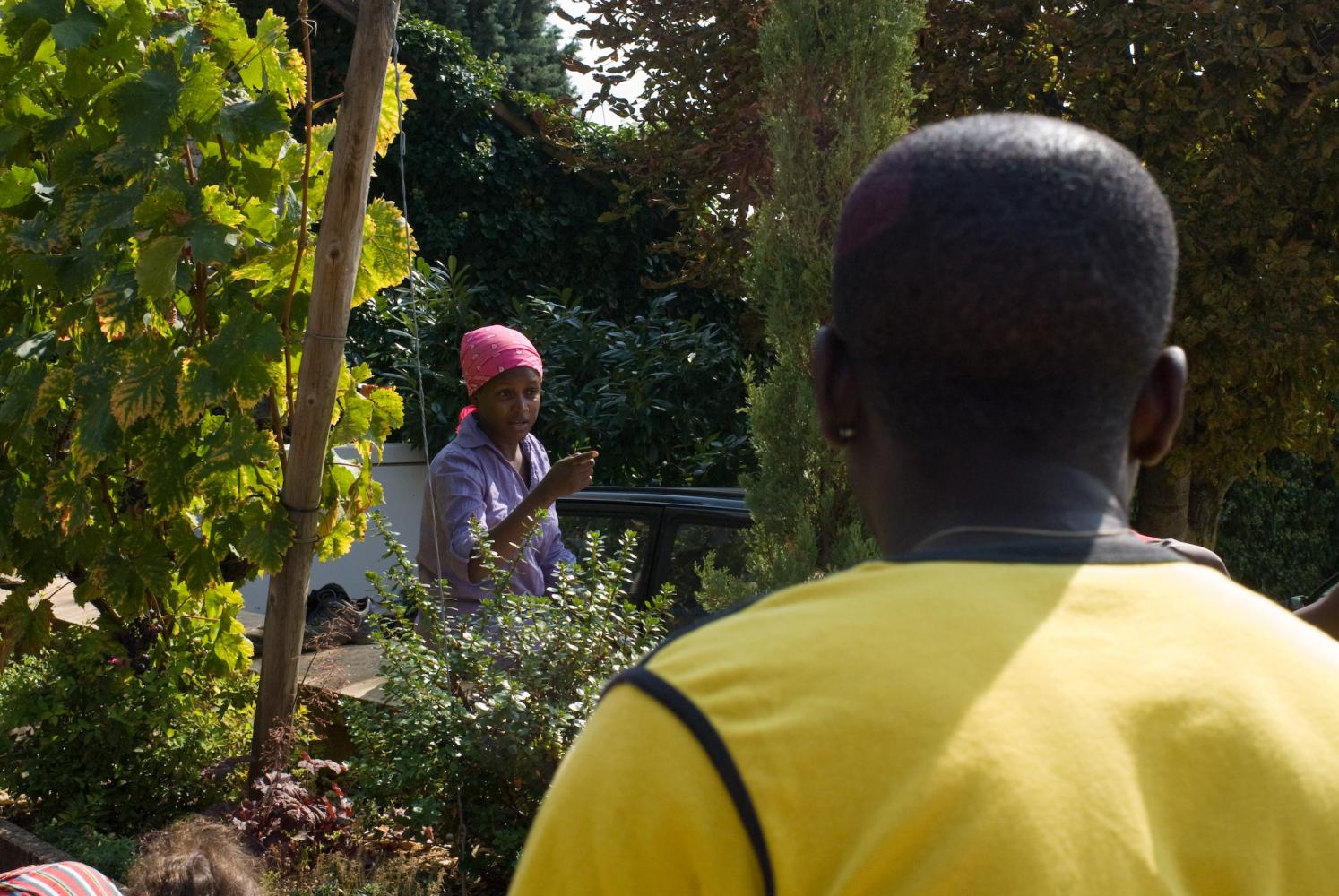 Devant la maison des Pillot à la pause déjeuner : Sheila, un foulard rose sur la tête, en pleine argumentation avec Brice, de dos, en t-shirt jaune. Chassagne-Montrachet, Bourgogne, septembre 2009.