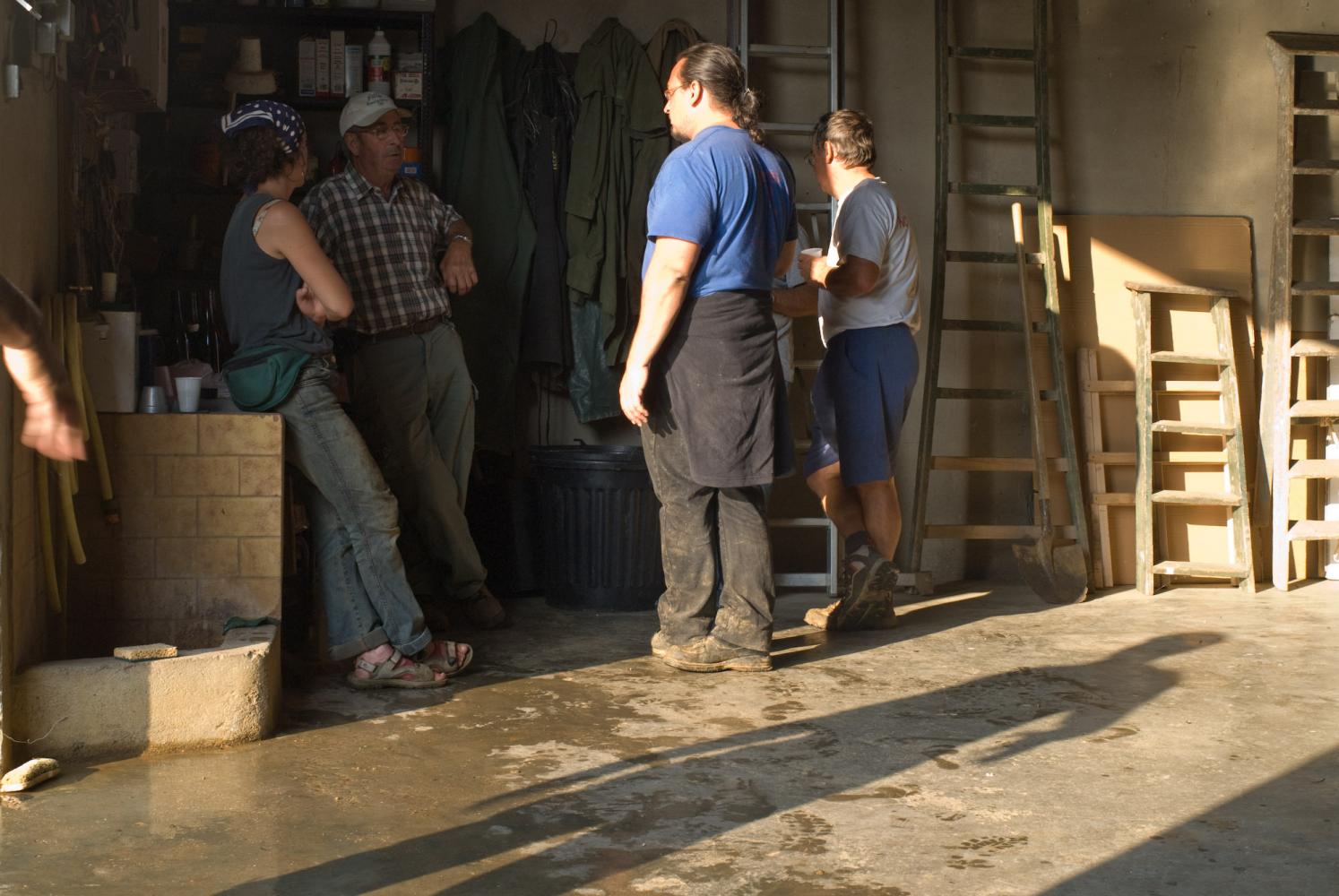 Trois vendangeurs parlent avec Fernand dans son garage. Chassagne-Montrachet, Bourgogne, septembre 2009.
